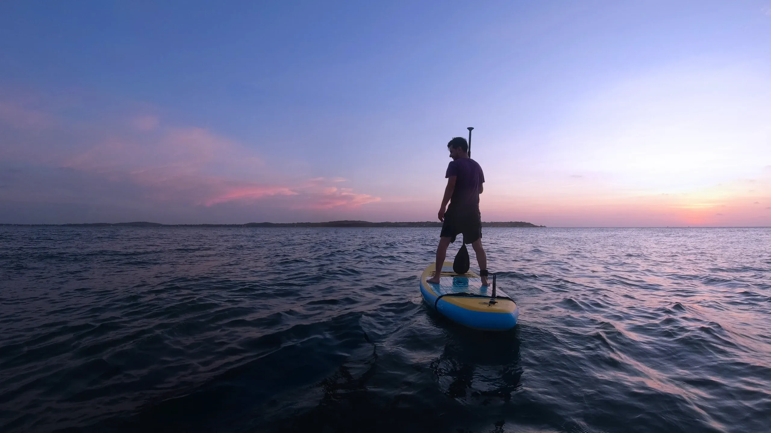 Carlos standing by the water at sunset.